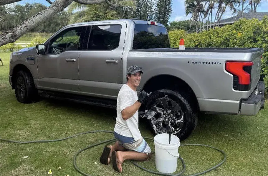 Jess Kraus of Mantra Auto Detailing hand-washing wheels on a truck on the North Shore